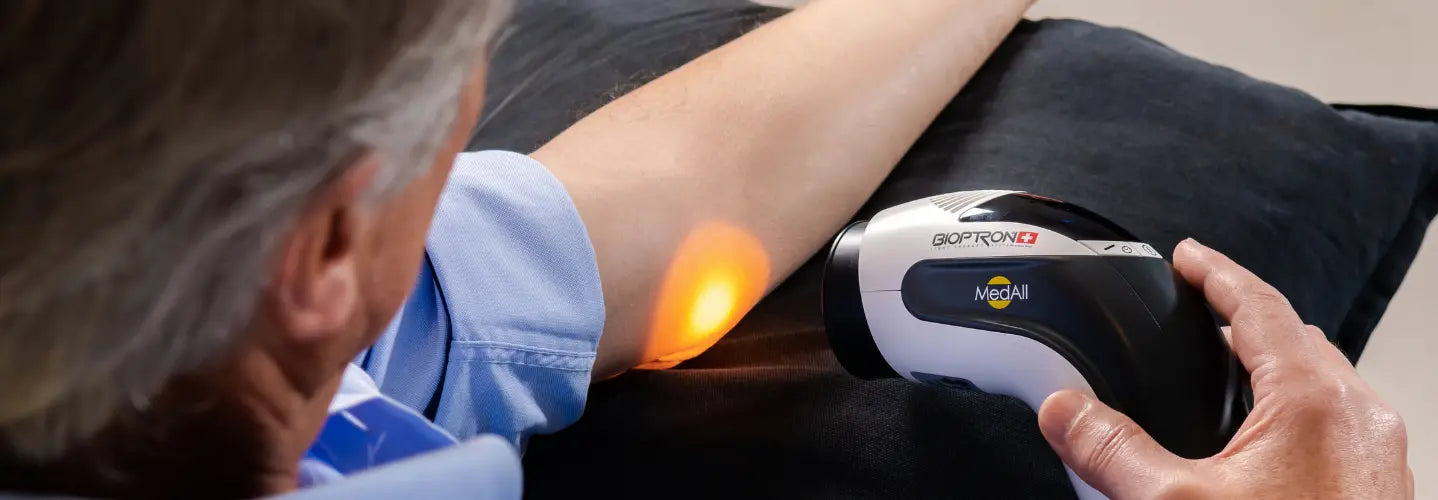 BIOPTRON light therapy device positioned hands-free beside a seated person for home wound-care support